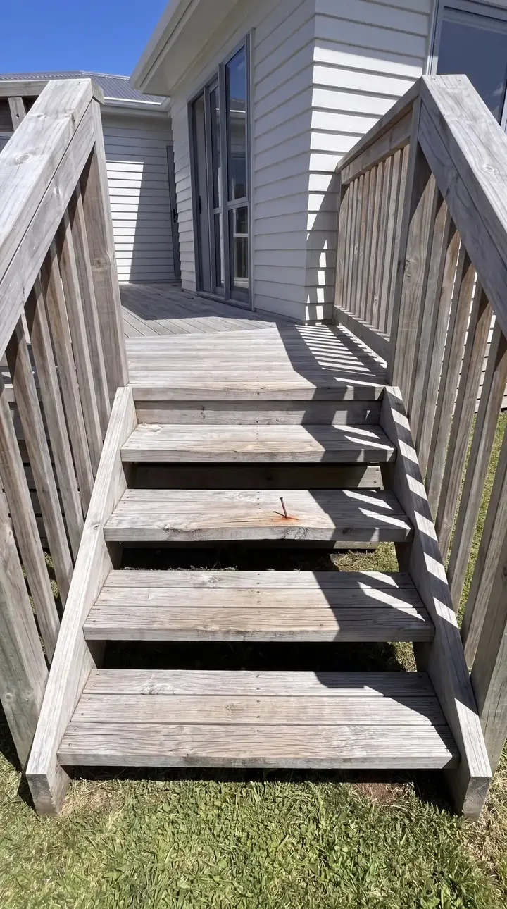 Timber deck stairs and balustrade leading up to a weatherboard house